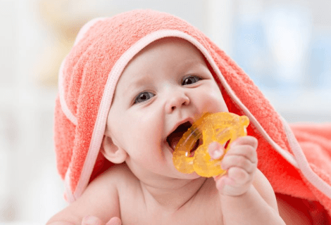 bebê com toalha e brinquedo